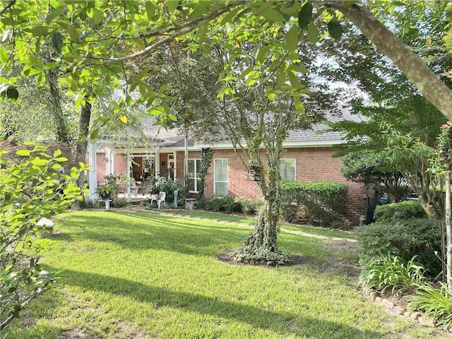 9849 Aspen Cir, Daphne, AL 36527 - view of front facade featuring brick siding, a front yard, and a pergola