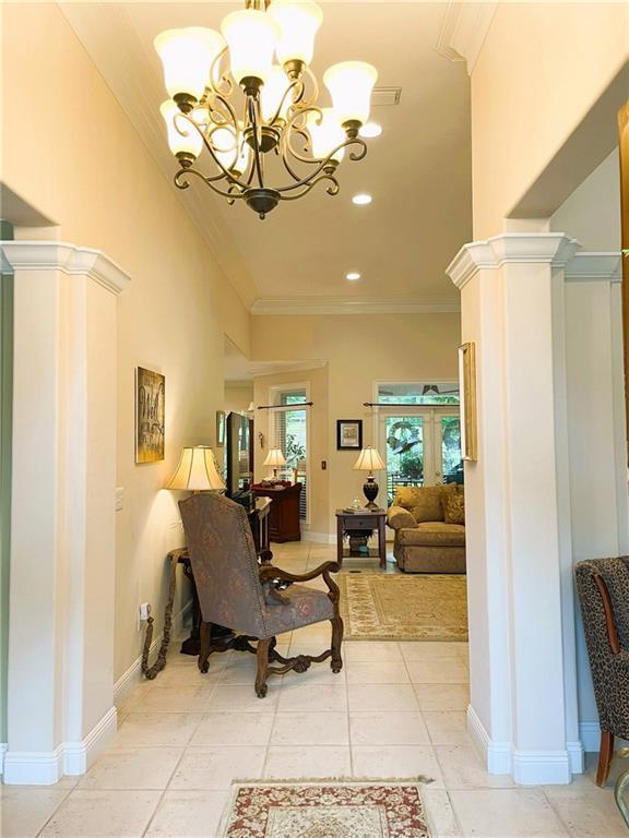 9849 Aspen Cir, Daphne, AL 36527 - living area featuring crown molding, a chandelier, ornate columns, recessed lighting, and light tile patterned floors