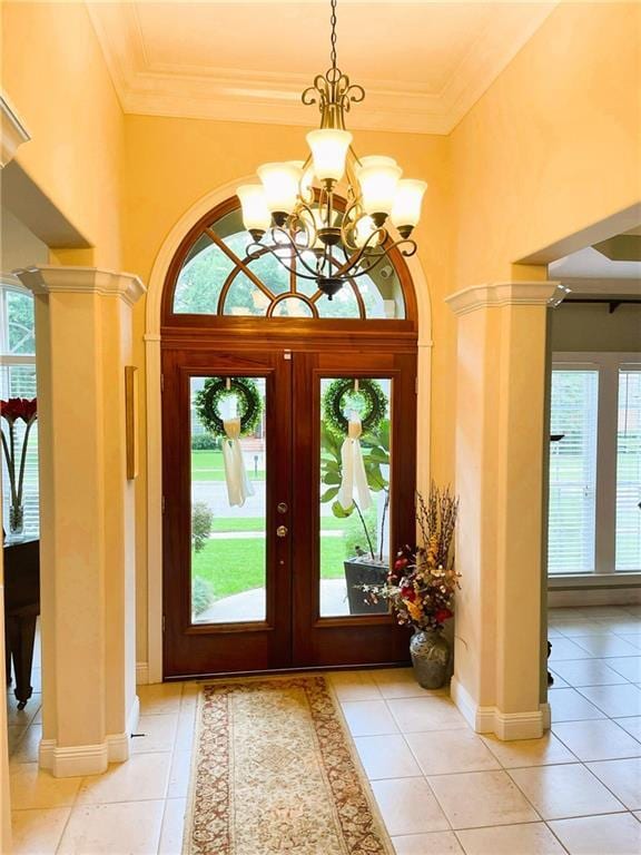 9849 Aspen Cir, Daphne, AL 36527 - entrance foyer featuring a chandelier, light tile patterned floors, ornate columns, crown molding, and a towering ceiling