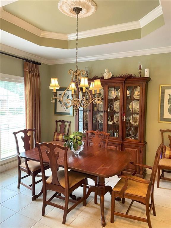 9849 Aspen Cir, Daphne, AL 36527 - dining space with a tray ceiling, light tile patterned flooring, a chandelier, and ornamental molding