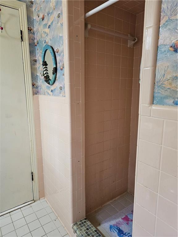 bathroom featuring a tile shower and tile patterned flooring