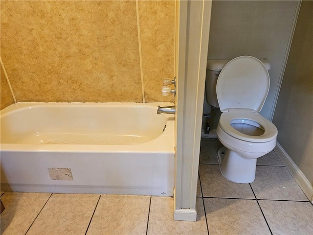 bathroom featuring tile patterned floors, a bathing tub, and toilet