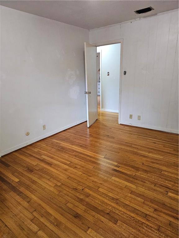 empty room with hardwood / wood-style flooring