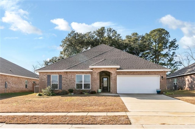 ranch-style home with central AC unit and a garage