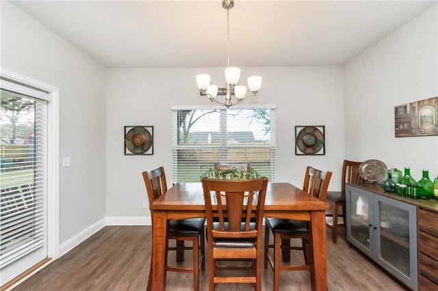 dining room with hardwood / wood-style flooring and an inviting chandelier