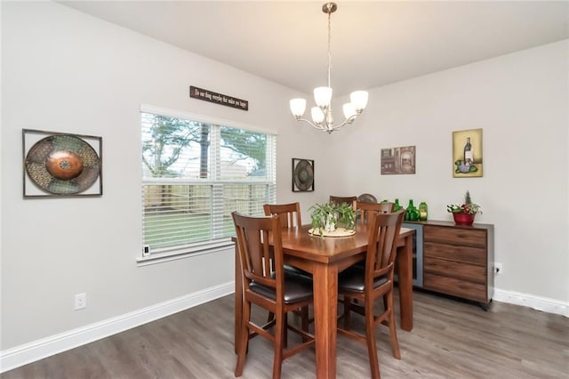 dining room with dark hardwood / wood-style flooring and a chandelier