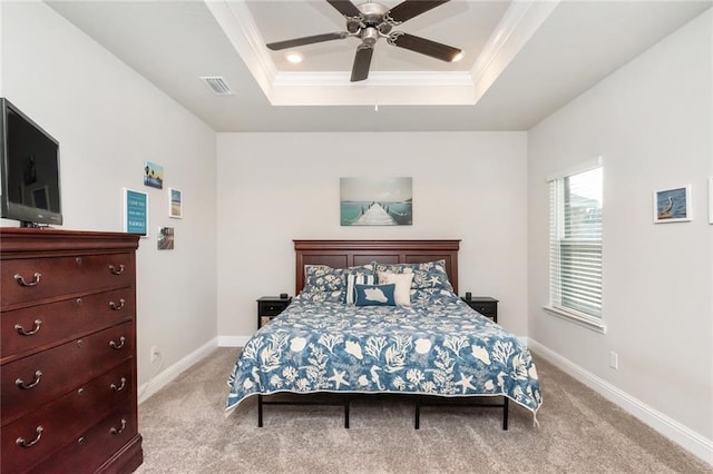 bedroom with a tray ceiling, ceiling fan, crown molding, and light carpet