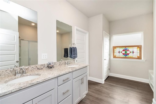 bathroom with vanity, wood-type flooring, and plus walk in shower