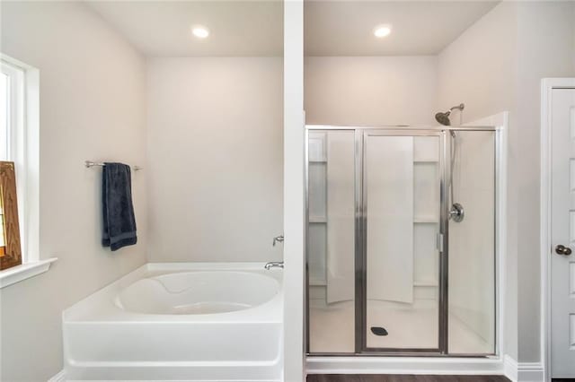 bathroom with hardwood / wood-style floors and separate shower and tub