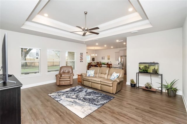 living room featuring a tray ceiling, ceiling fan, and dark hardwood / wood-style floors