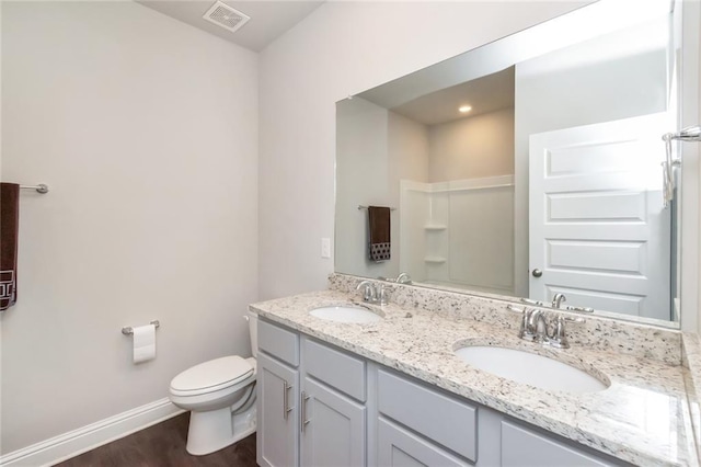 bathroom featuring a shower, wood-type flooring, vanity, and toilet