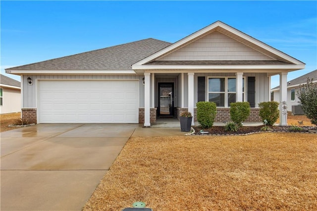 view of front facade featuring a garage, central AC, and a front lawn