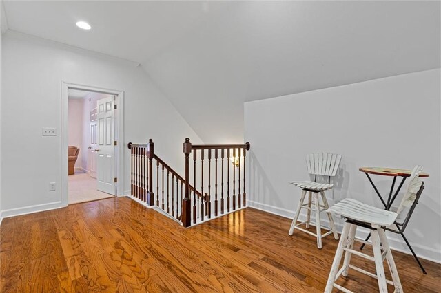 interior space featuring baseboards, an upstairs landing, and wood finished floors