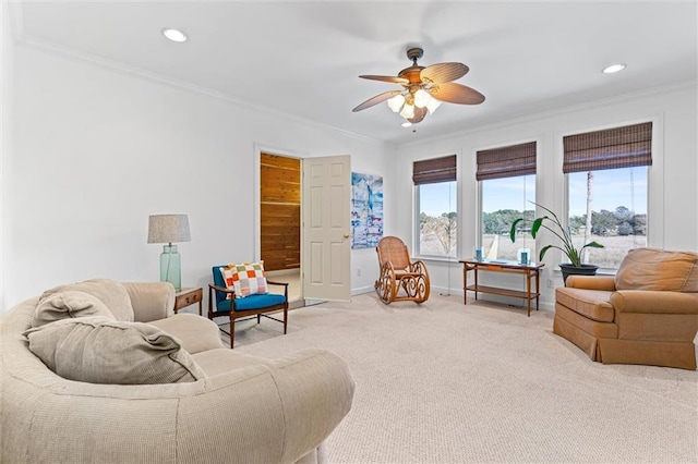 living area featuring baseboards, recessed lighting, ceiling fan, ornamental molding, and light carpet