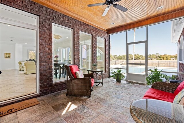 sunroom / solarium with ceiling fan, wooden ceiling, and ornate columns