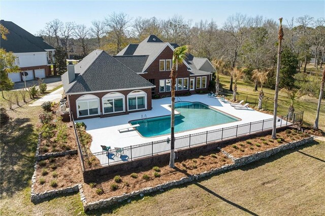 view of swimming pool with a patio area, a fenced in pool, a lawn, and fence