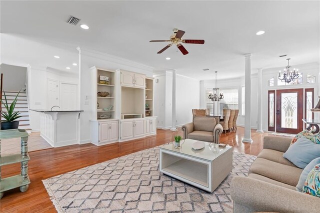 living room featuring visible vents, ornamental molding, recessed lighting, light wood-style floors, and ornate columns