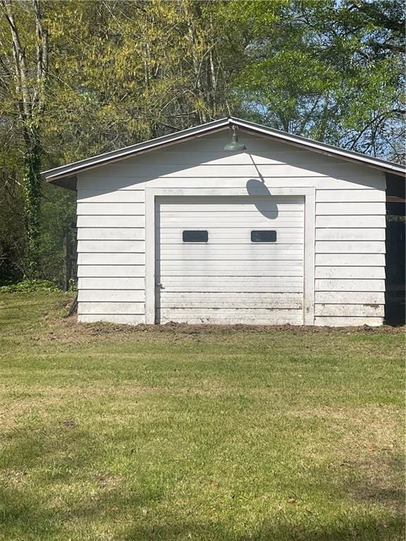 view of outdoor structure featuring a garage and a yard