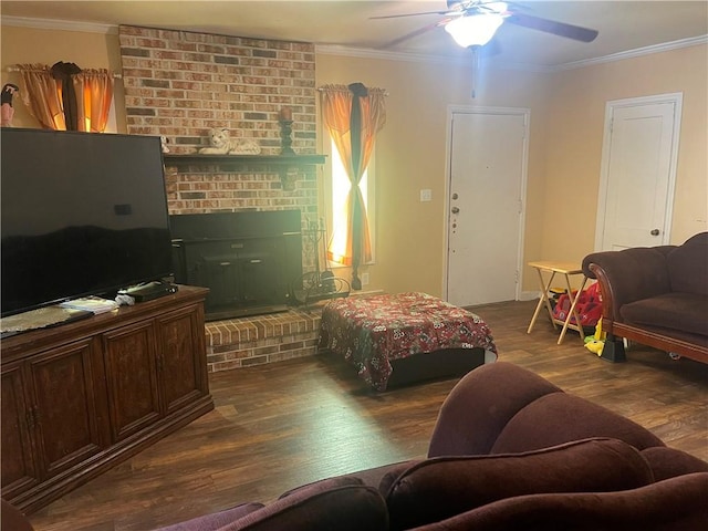 living room with dark hardwood / wood-style floors, a brick fireplace, ornamental molding, and ceiling fan