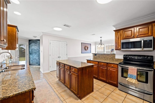 kitchen with sink, stainless steel appliances, a kitchen island, light tile patterned flooring, and ornamental molding