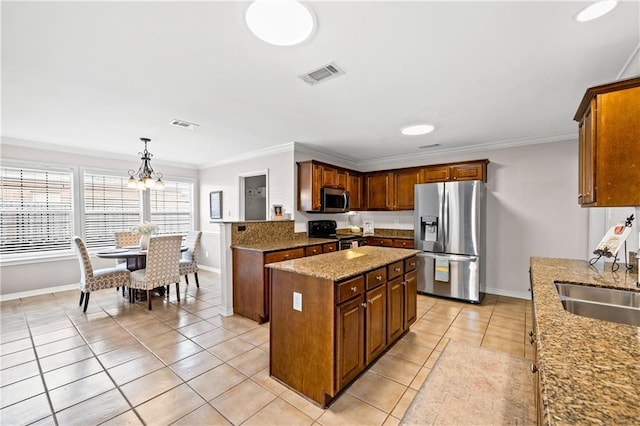 kitchen featuring a center island, hanging light fixtures, crown molding, appliances with stainless steel finishes, and a chandelier