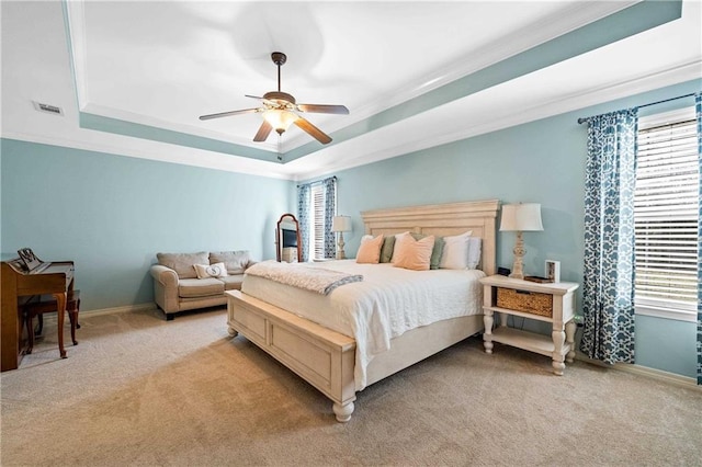 carpeted bedroom with ceiling fan, a raised ceiling, and crown molding