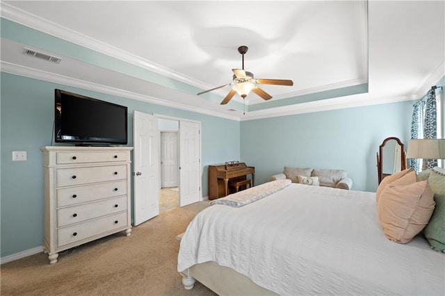 carpeted bedroom with a tray ceiling, ceiling fan, and ornamental molding