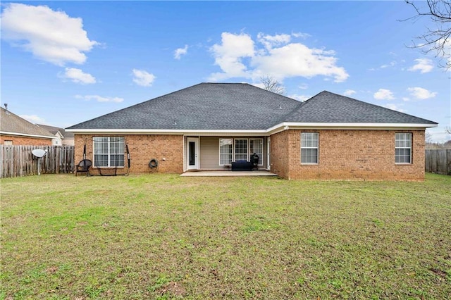 rear view of property featuring a yard and a patio