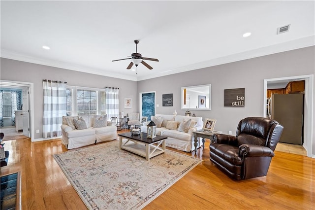 living room featuring ceiling fan, light wood-type flooring, and ornamental molding