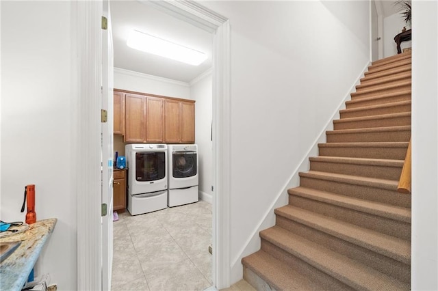 laundry room with ornamental molding, cabinets, light tile floors, and washing machine and clothes dryer