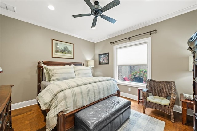 bedroom featuring ceiling fan, crown molding, and dark hardwood / wood-style floors