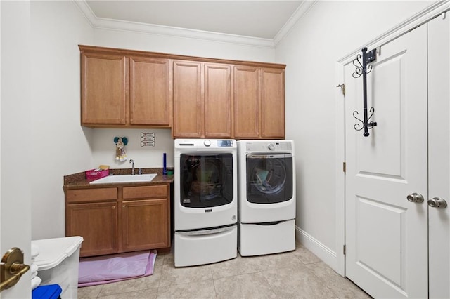 laundry room featuring light tile floors, cabinets, sink, washing machine and dryer, and ornamental molding