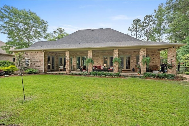 rear view of property with a patio area, french doors, and a yard