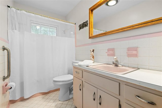 bathroom with tile walls, vanity, toilet, and a shower with curtain