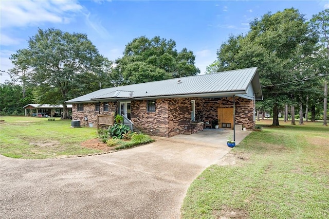 view of front of house featuring a carport, a front lawn, and central AC unit