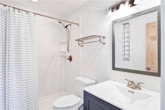 bathroom with toilet, a shower, and vanity