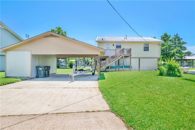 rear view of house with a carport and a yard