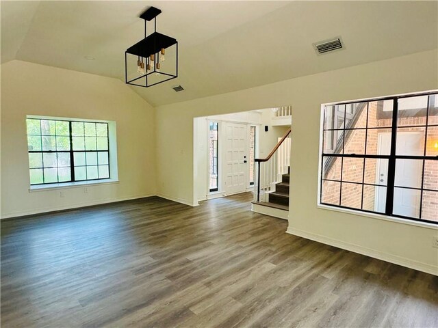 interior space featuring a notable chandelier, dark wood-type flooring, and lofted ceiling