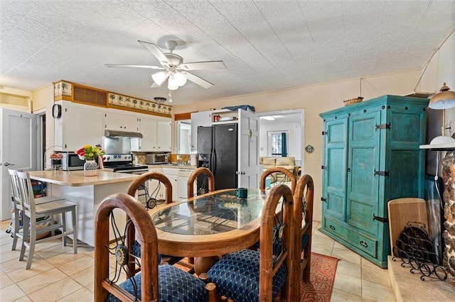 dining area featuring a toaster, light tile patterned flooring, and ceiling fan