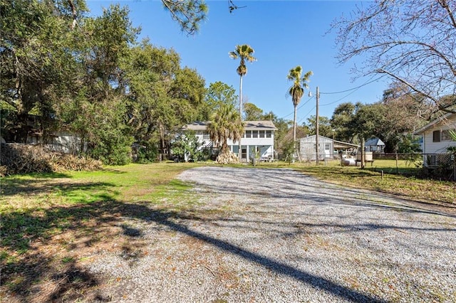 view of front of house featuring a front yard, fence, and driveway