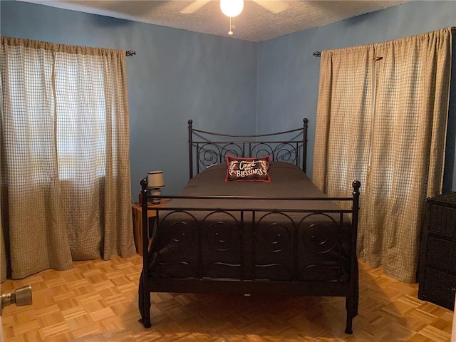 bedroom with ceiling fan and a textured ceiling