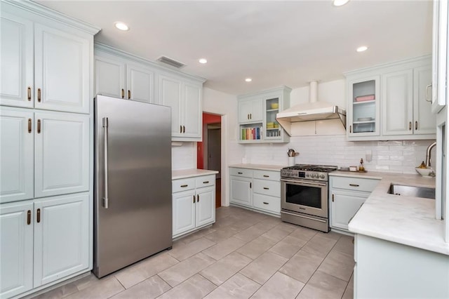 kitchen with white cabinets, range hood, sink, and appliances with stainless steel finishes