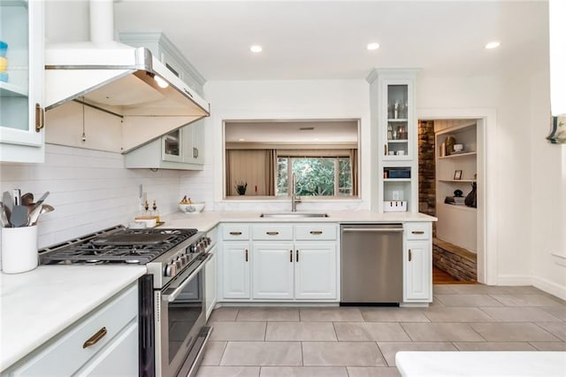 kitchen with white cabinets, appliances with stainless steel finishes, extractor fan, and sink