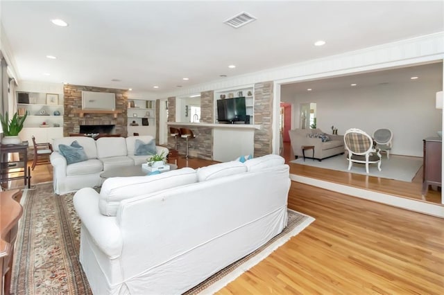 living room with a fireplace, hardwood / wood-style floors, and built in features