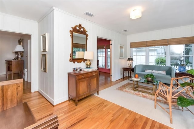 living room with light hardwood / wood-style floors and ornamental molding