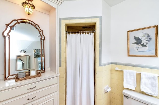 bathroom featuring curtained shower, tile walls, and toilet