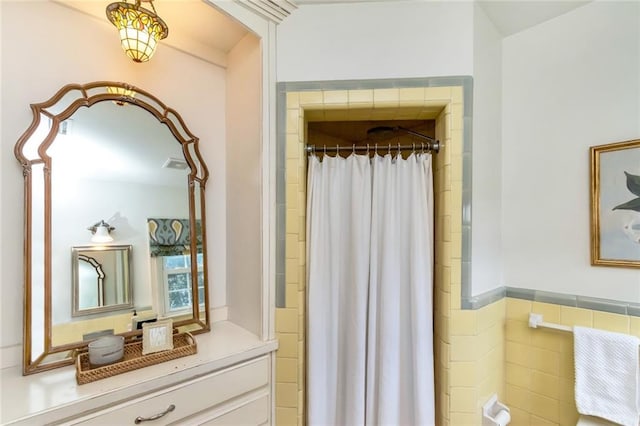 bathroom featuring curtained shower and tile walls