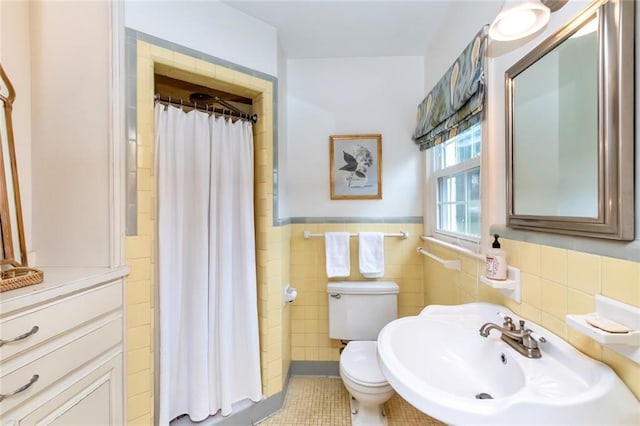 bathroom featuring tile patterned floors, sink, toilet, tile walls, and curtained shower