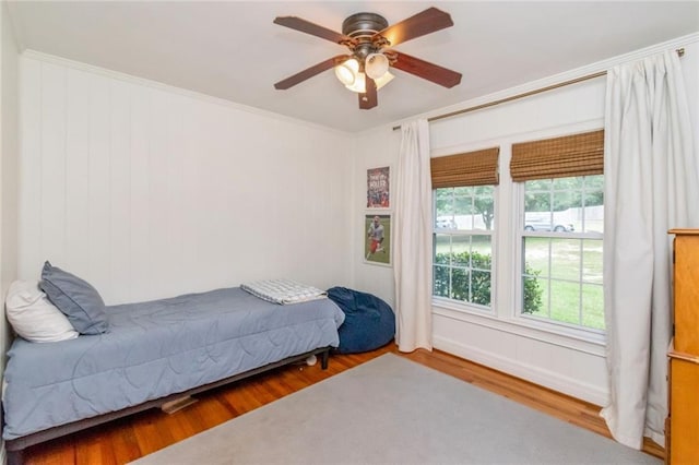 bedroom with ceiling fan, hardwood / wood-style floors, and crown molding