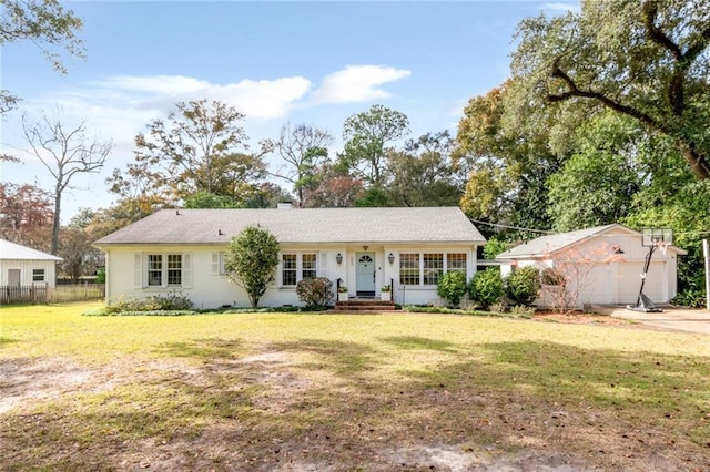 ranch-style home featuring an outbuilding, a front yard, and a garage